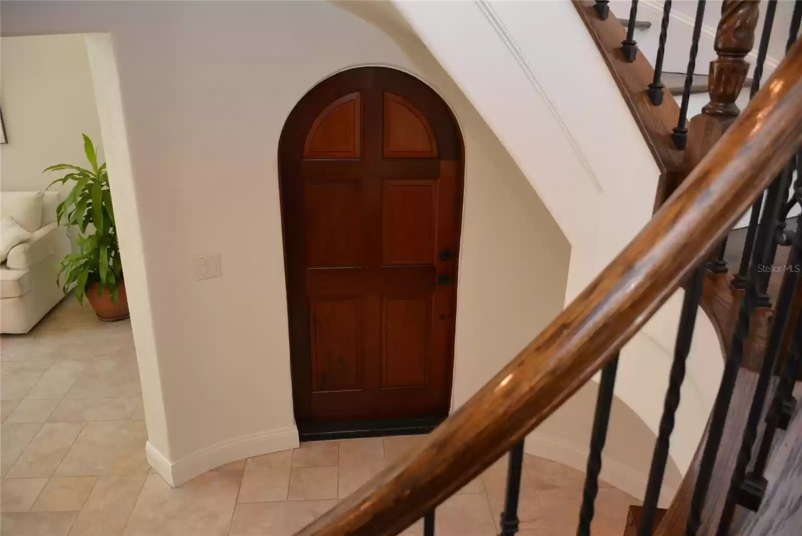 Enter the front door into the foyer that includes an elegant hardwood and wrought iron spiral staircase.