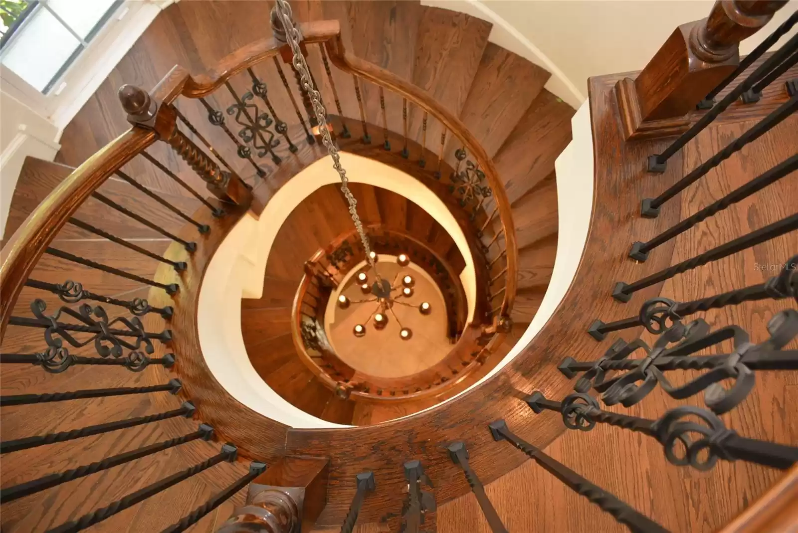 Elegant hardwood and wrought-iron spiral staircase rising to the top of the turret.
