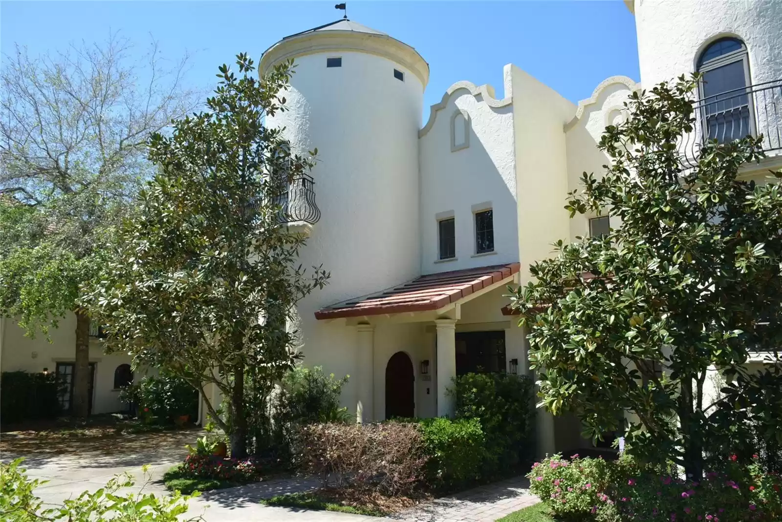 An architectural gem with exterior features including Spanish stucco finishes, turrets, balconies and arched doorways