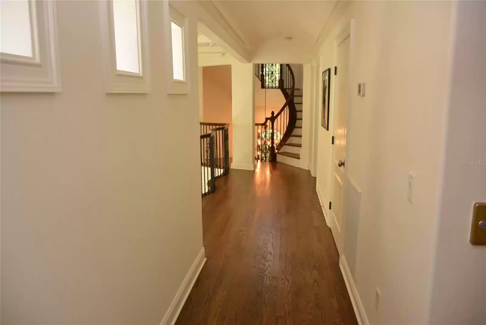 Hardwood floors extend from the balcony/hallway into the owner’s bedroom suite with dual walk-in closets, vaulted ceiling and private balcony