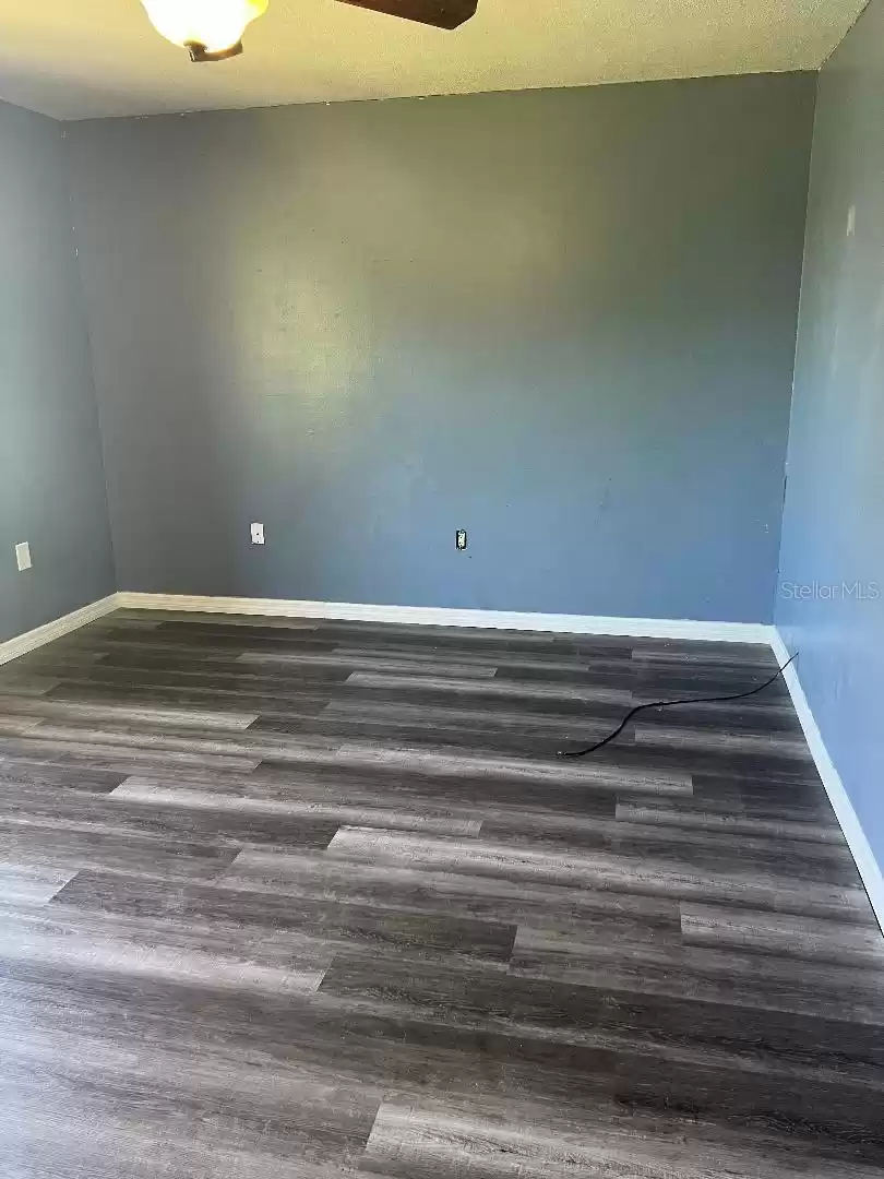 Second bedroom with new vinyl flooring and baseboards.