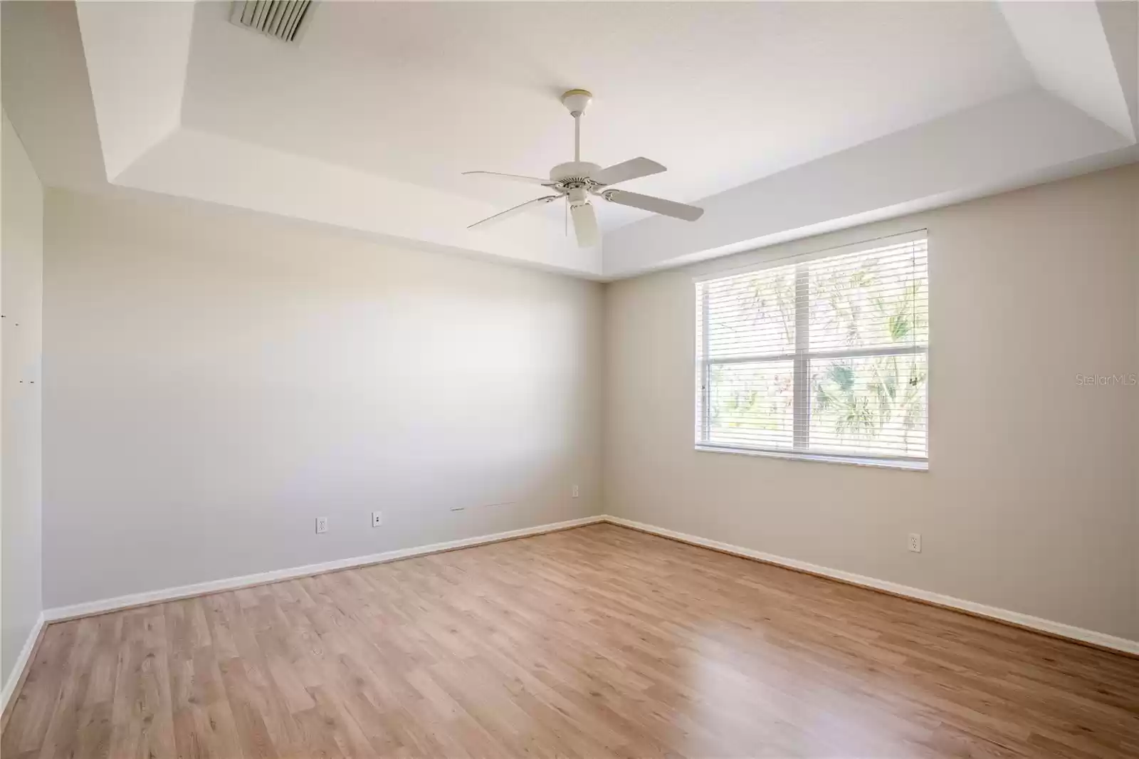large primary bedroom with trey ceilings and lots of natural light and great views